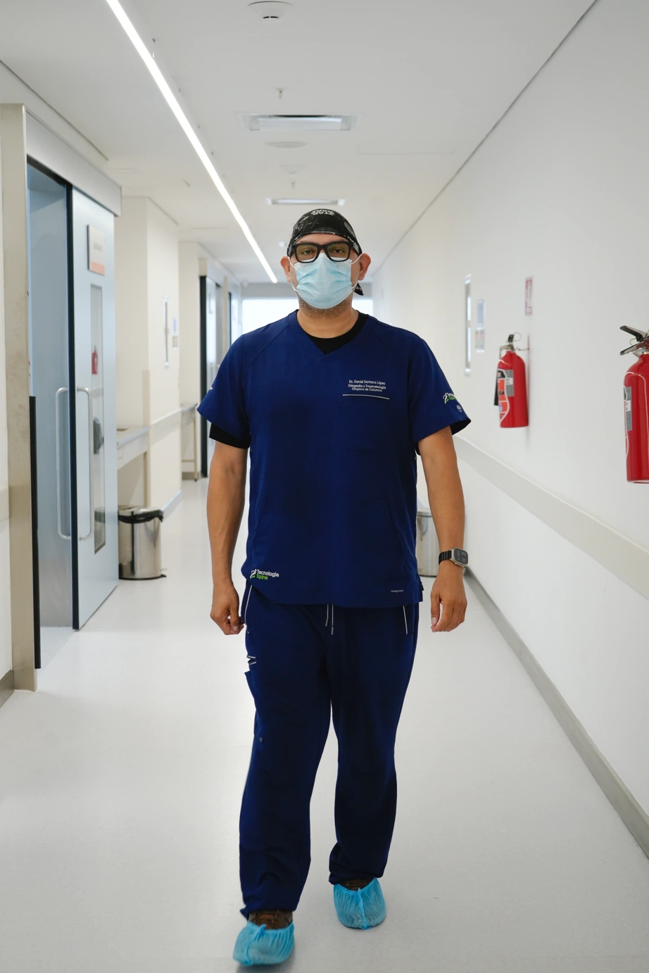Dr. Daniel Santana López caminando por un pasillo de hospital